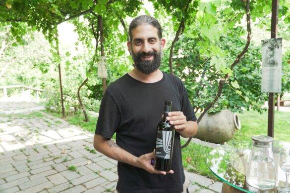 Mann hält Weinflasche in Armenien