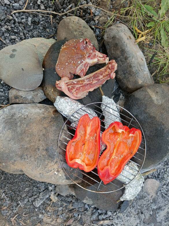 Fleisch und Gemüse auf einem Feuer in Kirgistan.