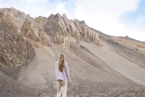 Junge Frau vor schroffen Bergen in kirgistan