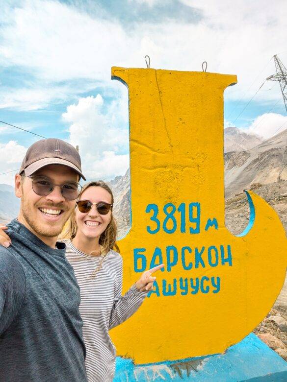 Paar vor einer Höhentafel am Suyek Pass