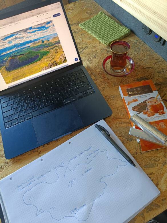 Laptop und Notizblock auf einem Tisch mit Esswaren.