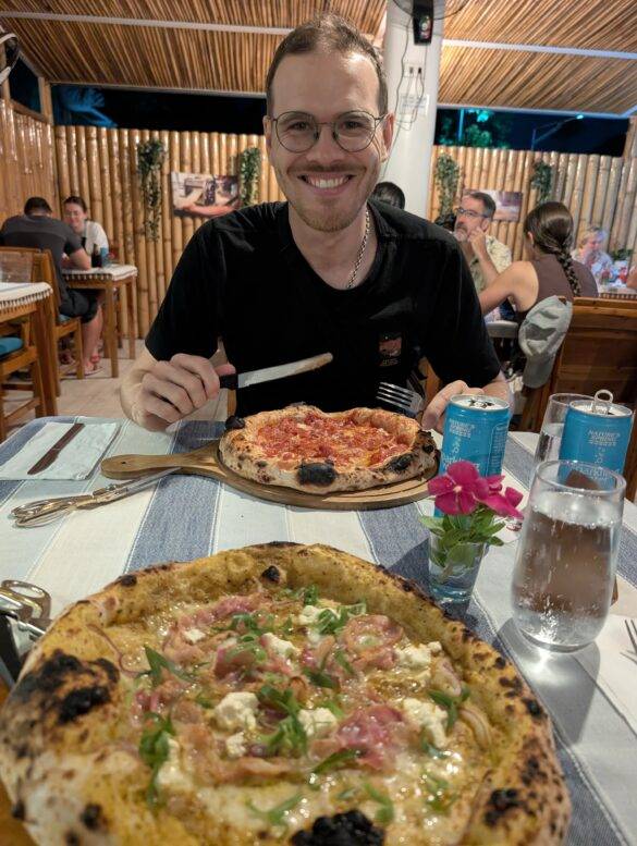 Mann an einem Tisch mit servierter Pizza